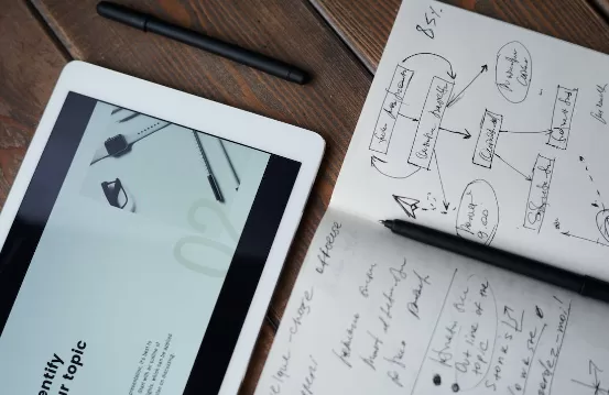 Image of a pen, a notepad, and a tablet