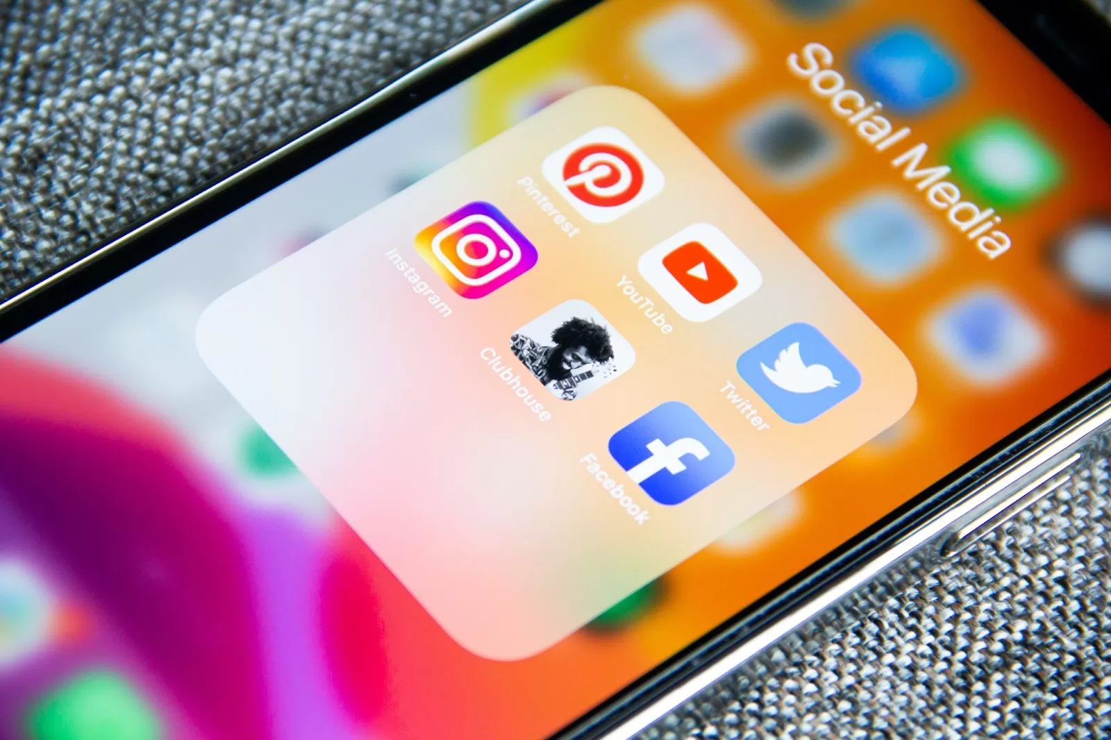 An iPhone with social media platforms icons on the screen