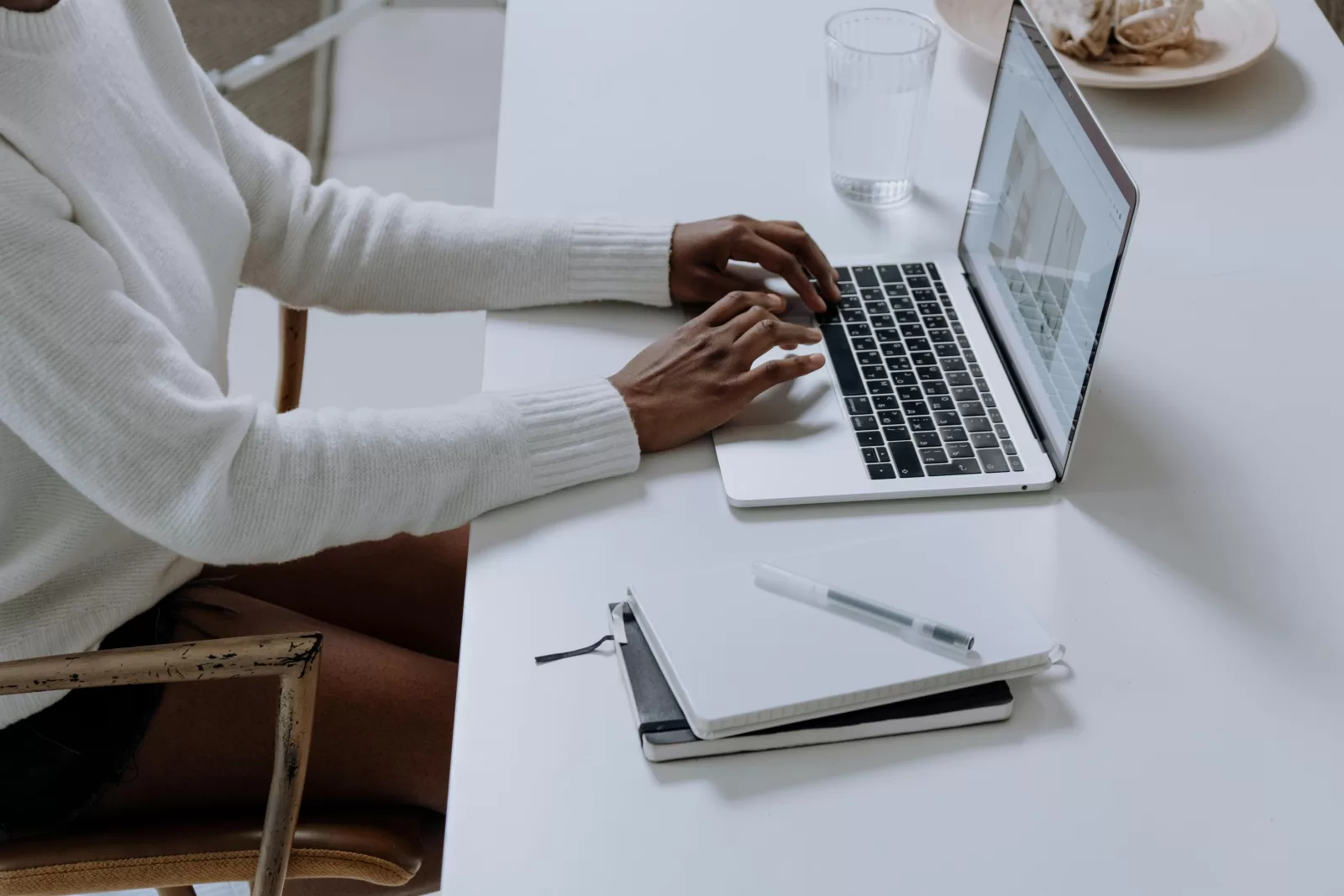 Person using MacBook pro on white table